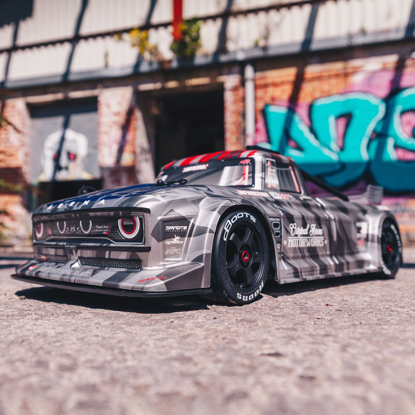 1/7 ARRMA INFRACTION 6S AVC 4X4 RTR - race car with camouflage pattern on a street with graffiti in the background