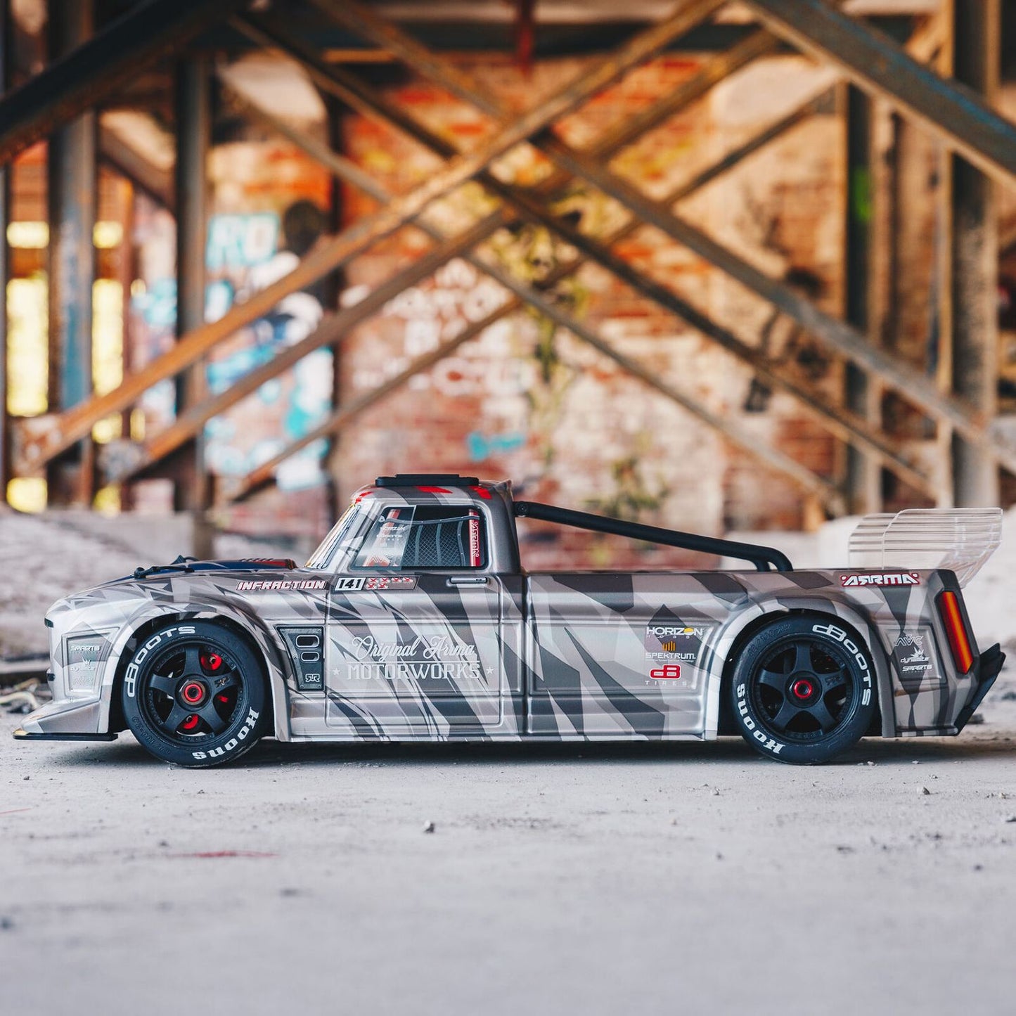 1/7 ARRMA INFRACTION 6S AVC 4X4 RTR - truck body on a concrete surface with a graffiti-covered wall in the background