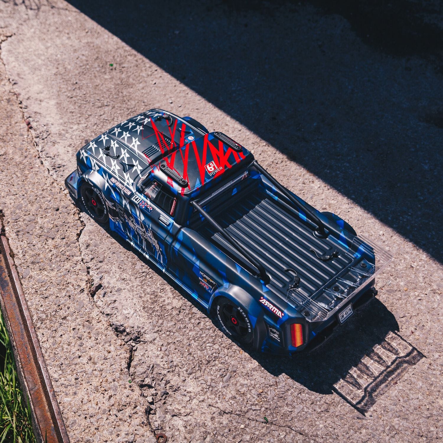 1/7 ARRMA INFRACTION 6S AVC 4X4 RTR - Blue on-road vehicle with red and white graphics on a concrete surface
