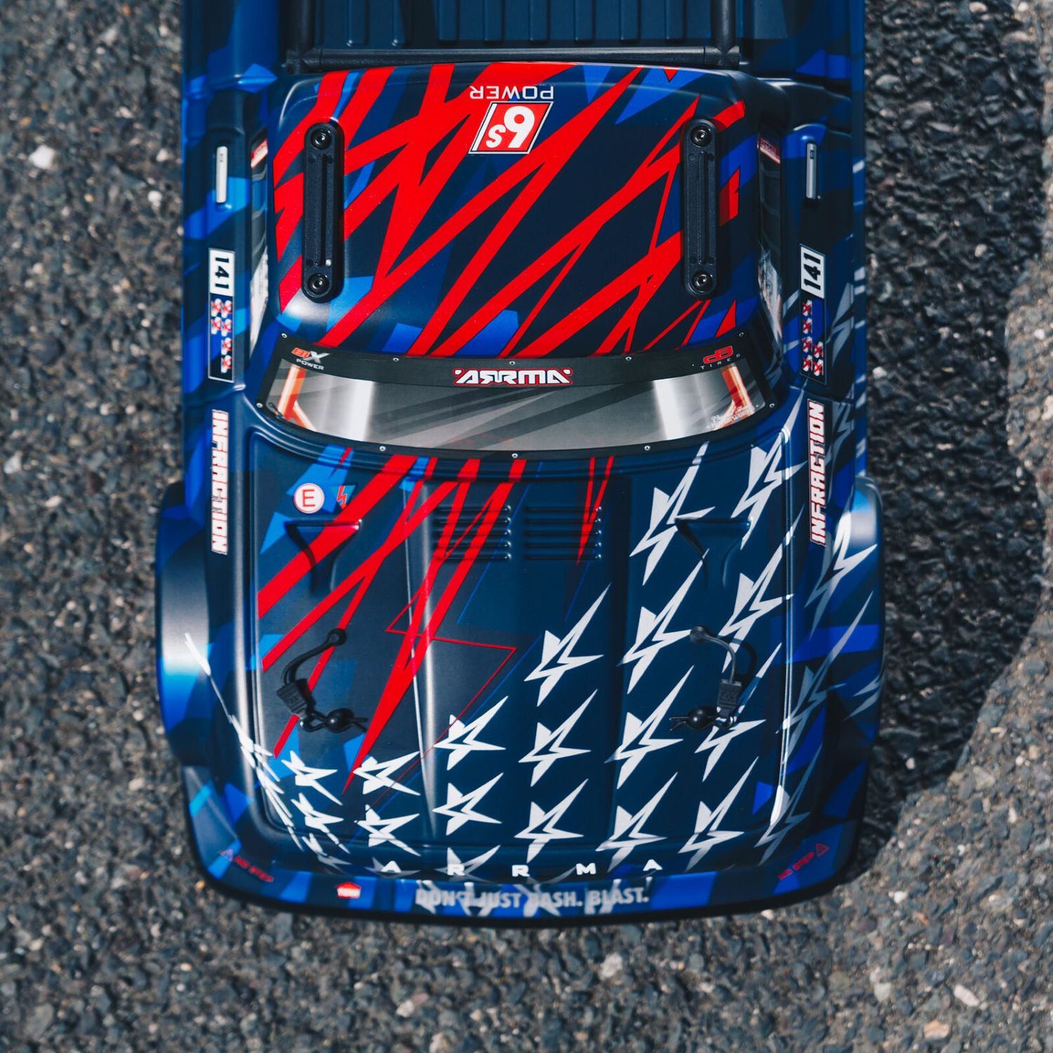 1/7 ARRMA INFRACTION 6S AVC 4X4 RTR - Top view of a colorful racing car with star pattern on asphalt