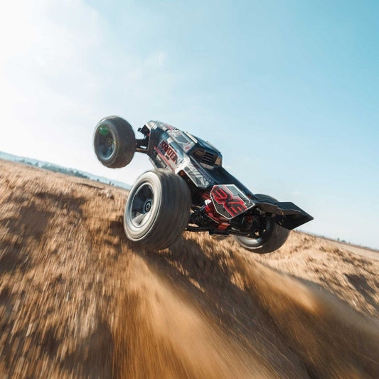 1/8 ARRMA KRATON 6S EXB 4X4 RTR Brushless Speed Truck - Off-road vehicle in mid-air over a dirt hill with a clear sky.