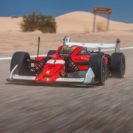 1/7 ARRMA LIMITLESS 120 8S AVC 4X4 RTR - Red and black car on a desert race track with blurred motion effect.