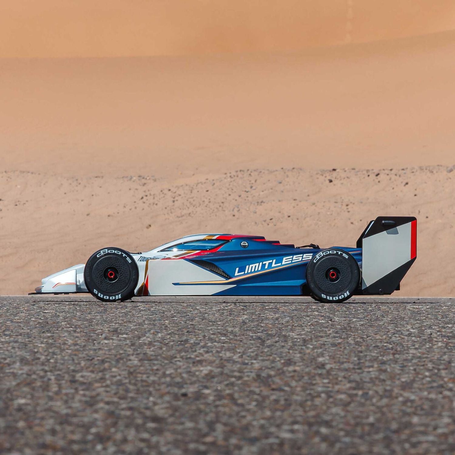 1/7 ARRMA LIMITLESS 120 8S AVC 4X4 RTR white and blue - racing car on a track with a desert background